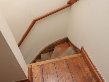 A wooden spiral staircase with a handrail and wooden floor at Ty Llugwy in Capel Curig near Betws-Y-Coed