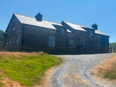 A house with a gate and gravel driveway at Ty Llugwy in Capel Curig near Betws-Y-Coed