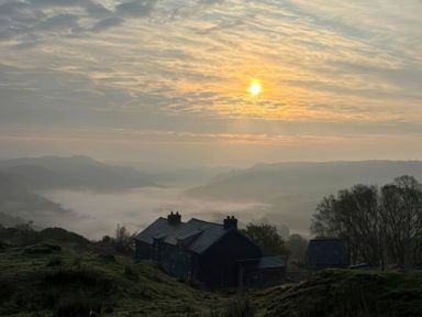 A scenic view of houses and hills during sunrise at Ty Llugwy in Capel Curig near Betws-Y-Coed