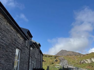 A building with a path leading to a mountain at Ty Siabod in Capel Curig near Betws-Y-Coed