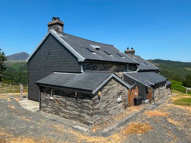A house with a stone exterior and slate roof at Ty Llewelyn in Capel Curig near Betws-Y-Coed