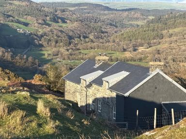 A house on a hillside with a landscape view at Ty Llewelyn in Capel Curig near Betws-Y-Coed