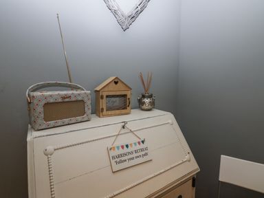 A white desk with a decorative radio a wooden key holder and a silver diffuser at 1 Boarbank Farm in Allithwaite near Cartmel