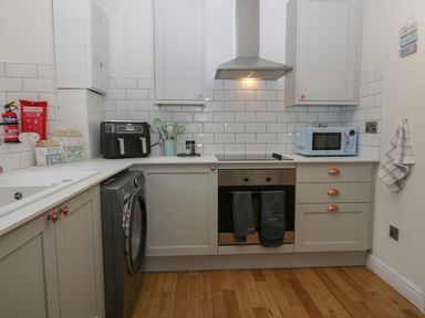 A kitchen with washing machine oven microwave and kitchen utensils at 1 Boarbank Farm Allithwaite near Cartmel