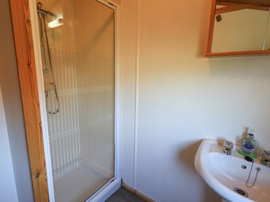 A bathroom with a shower enclosure and a sink with soap at Kellet Lodge Lakeside 26 Dock Acres near Carnforth