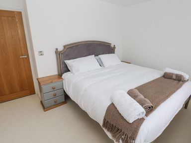 A bedroom with a double bed and bedside table at Golygfa Hafan in Little Haven