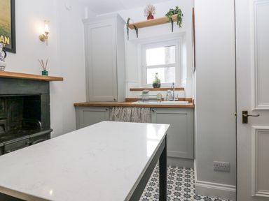 A kitchen with a sink and cabinets at 11A High Street in Jedburgh