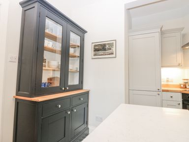 A hutch with dishes and a framed picture at 11A High Street in Jedburgh