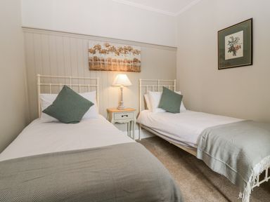 A bedroom with two single beds and a nightstand at 11A High Street, Jedburgh