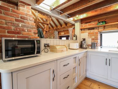 A kitchen countertop with microwave toaster bread box coffee maker and kettle at Bridge Barn in Sidestrand near Overstrand
