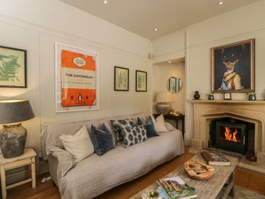 A living room with a sofa, fireplace, and coffee table at Cotswold House in Moreton-In-Marsh