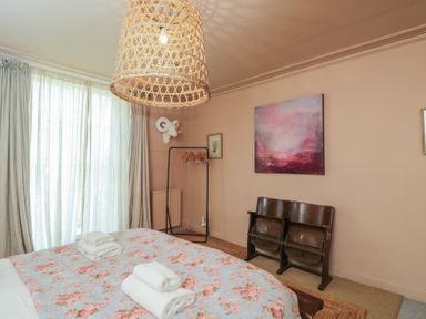 A bedroom with a bed and artwork on the wall at Cotswold House in Moreton-In-Marsh