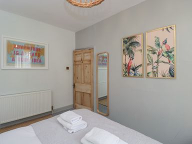 A bedroom with a bed and artworks at Cotswold House in Moreton-In-Marsh