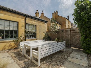 A garden with a table and benches at Cotswold House in Moreton-In-Marsh