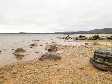 A lakeshore with rocks along the water and hills in the distance at Lakeview Lodge in Knockmore County Mayo