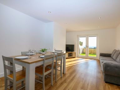 A dining room with a table and chairs at 15 Llys Tegeirian Llangristiolus near Llangefni