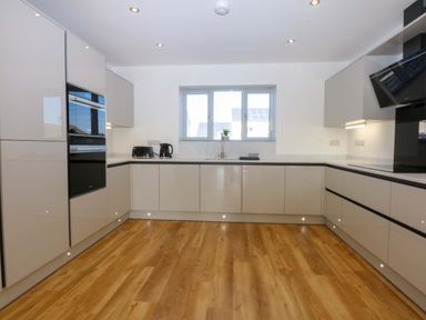 A kitchen with modern cabinets and appliances at 15 Llys Tegeirian Llangristiolus near Llangefni