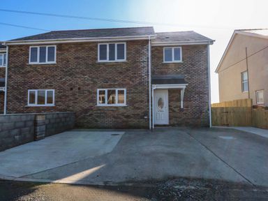 A house with a driveway at 15 Llys Tegeirian in Llangristiolus near Llangefni