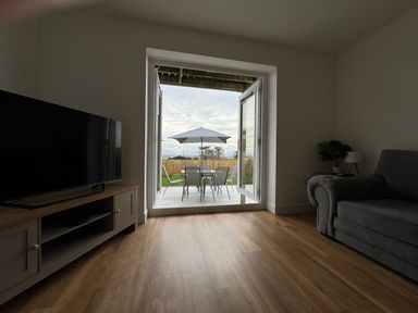 A living room with a television and sofa at Golygfa in Llangristiolus near Llangefni