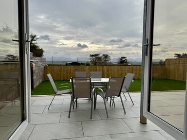 A garden with a table and chairs at Golygfa in Llangristiolus near Llangefni
