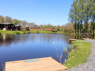 An outdoor area with cabins by a lake at Lakeview Lodge Forton near Garstang