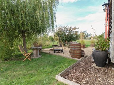 An outdoor area with a table and chairs at Bonnie's Shepherds Hut at Shepherds Lodge Retreat and Wellness in Bottesford near Redmile and Vale of Belvoir