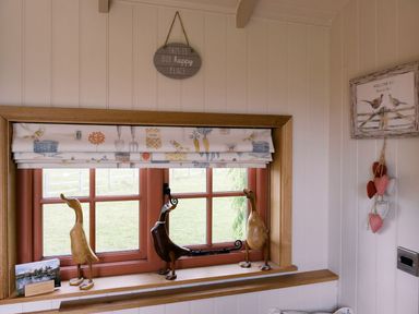 A window with decorative figurines and a picture frame at Bonnie's Shepherds Hut at Shepherds Lodge Retreat and Wellness Bottesford near Redmile and Vale of Belvoir