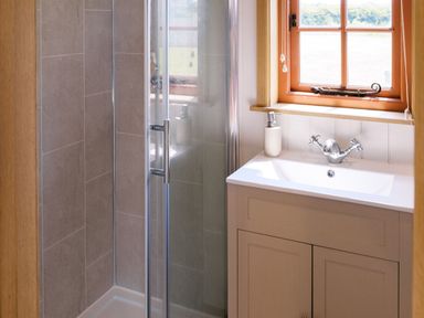 A bathroom with a shower and sink at Bonnie's Shepherds Hut at Shepherds Lodge Retreat and Wellness Bottesford near Redmile and Vale of Belvoir