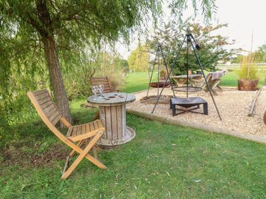 A garden with a table and chairs at Bonnie's Shepherds Hut at Shepherds Lodge Retreat and Wellness Bottesford near Redmile and Vale of Belvoir