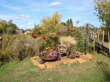 A garden with flower pots and metal sculptures at Bonnie's Shepherds Hut at Shepherds Lodge Retreat and Wellness in Bottesford near Redmile and Vale of Belvoir