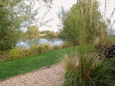 A garden with a view of a pond at Bonnie's Shepherds Hut at Shepherds Lodge Retreat and Wellness Bottesford near Redmile and Vale of Belvoir