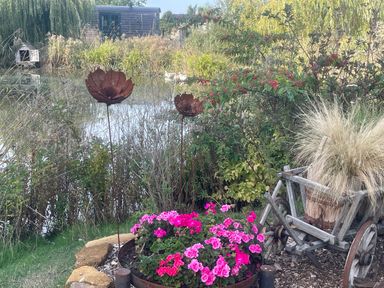 A garden with flowers and metal sculptures at Bonnie's Shepherds Hut at Shepherds Lodge Retreat and Wellness Bottesford near Redmile and Vale of Belvoir