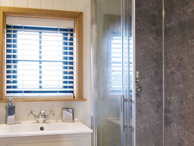 A bathroom with a sink and shower at Lillie's Shepherds Hut at Shepherds Lodge Retreat and Wellness in Bottesford near Redmile and Vale of Belvoir