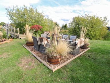 An outdoor seating area with chairs and a table at Lillie's Shepherds Hut at Shepherds Lodge Retreat and Wellness Bottesford near Redmile and Vale of Belvoir