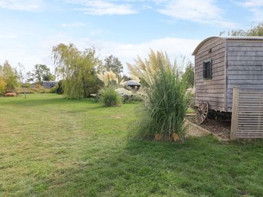 A shepherd's hut in a grassy area at Lillie's Shepherds Hut at Shepherds Lodge Retreat and Wellness, Bottesford near Redmile and Vale of Belvoir