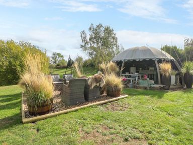 A garden with outdoor seating and planters at Poppie's Shepherds Hut at Shepherds Lodge Retreat and Wellness Bottesford near Redmile and Vale of Belvoir