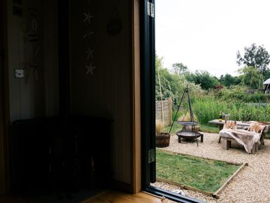 A view from an indoor area to an outdoor seating space at Poppie's Shepherds Hut at Shepherds Lodge Retreat and Wellness Bottesford near Redmile and Vale of Belvoir