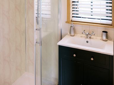 A bathroom with a shower and sink at Poppie's Shepherds Hut at Shepherds Lodge Retreat and Wellness Bottesford near Redmile and Vale of Belvoir
