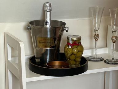 A bar area with a champagne bucket and jar of olives at Poppie's Shepherds Hut at Shepherds Lodge Retreat and Wellness Bottesford near Redmile and Vale of Belvoir