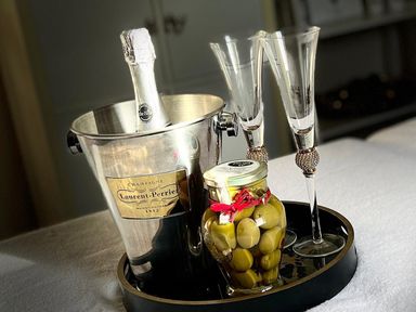 A champagne bottle with glasses and olives on a tray at Poppie's Shepherds Hut at Shepherds Lodge Retreat and Wellness, Bottesford near Redmile and Vale of Belvoir