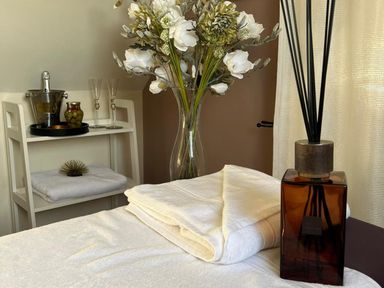 A spa room with towels and flowers at Poppie's Shepherds Hut at Shepherds Lodge Retreat and Wellness, Bottesford near Redmile and Vale of Belvoir