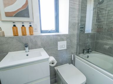 A bathroom with a sink, toilet, bathtub, and shower at 6 Gwel Yr Wyddfa in Llanfaelog near Rhosneigr