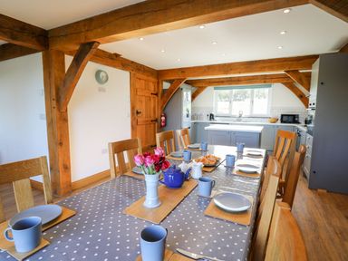 A kitchen with a dining table set for tea including cups plates and a teapot at Yr Adfa Llangeitho near Tregaron