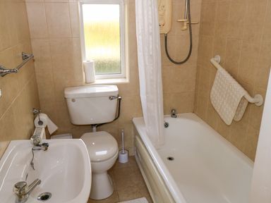 A bathroom with a toilet sink and bathtub with shower at Robin's Roost 2 in Cornamona County Galway