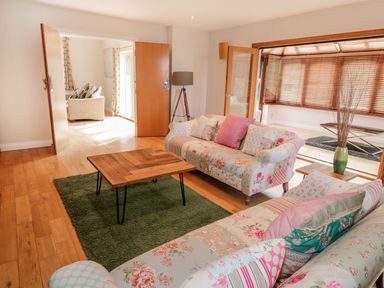 A living room with floral sofas a wooden coffee table and a green rug at Walworth Castle Lodge Walworth near Darlington