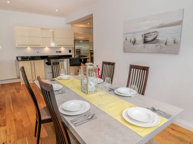 A dining table set with plates glasses and cutlery in a kitchen dining area at Walworth Castle Lodge in Walworth near Darlington