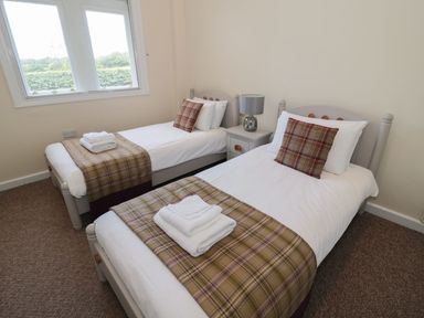 A bedroom with two single beds and a nightstand with a lamp at Walworth Castle Lodge in Walworth near Darlington
