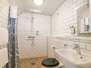 A bathroom with a walk-in shower a sink a toilet with a black seat and a mirror at Moles Cottage Farnham near Sixpenny Handley