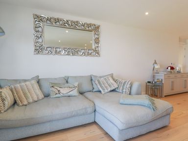 A living room with a sofa and a mirror at Apartment 8 