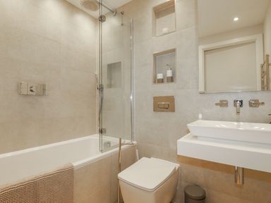 A bathroom with a bathtub and shower in Apartment 8 
